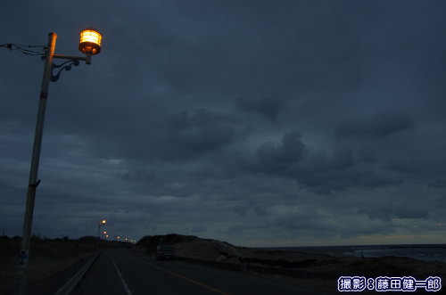 根本海岸の道路に並ぶ低圧ナトリウム灯に球替えされている街灯。右下が海。